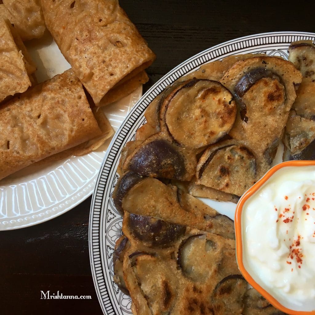 A plate of food on a table, with Eggplant and Dosa