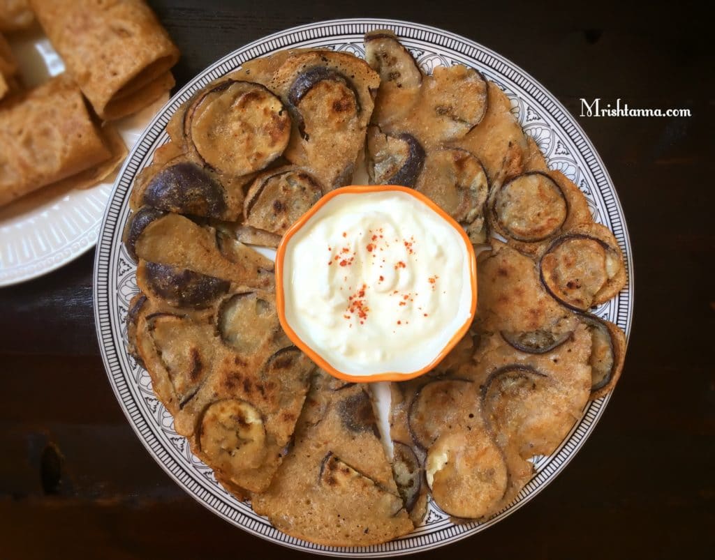 A plate of food on a table, with Eggplant and Dosa