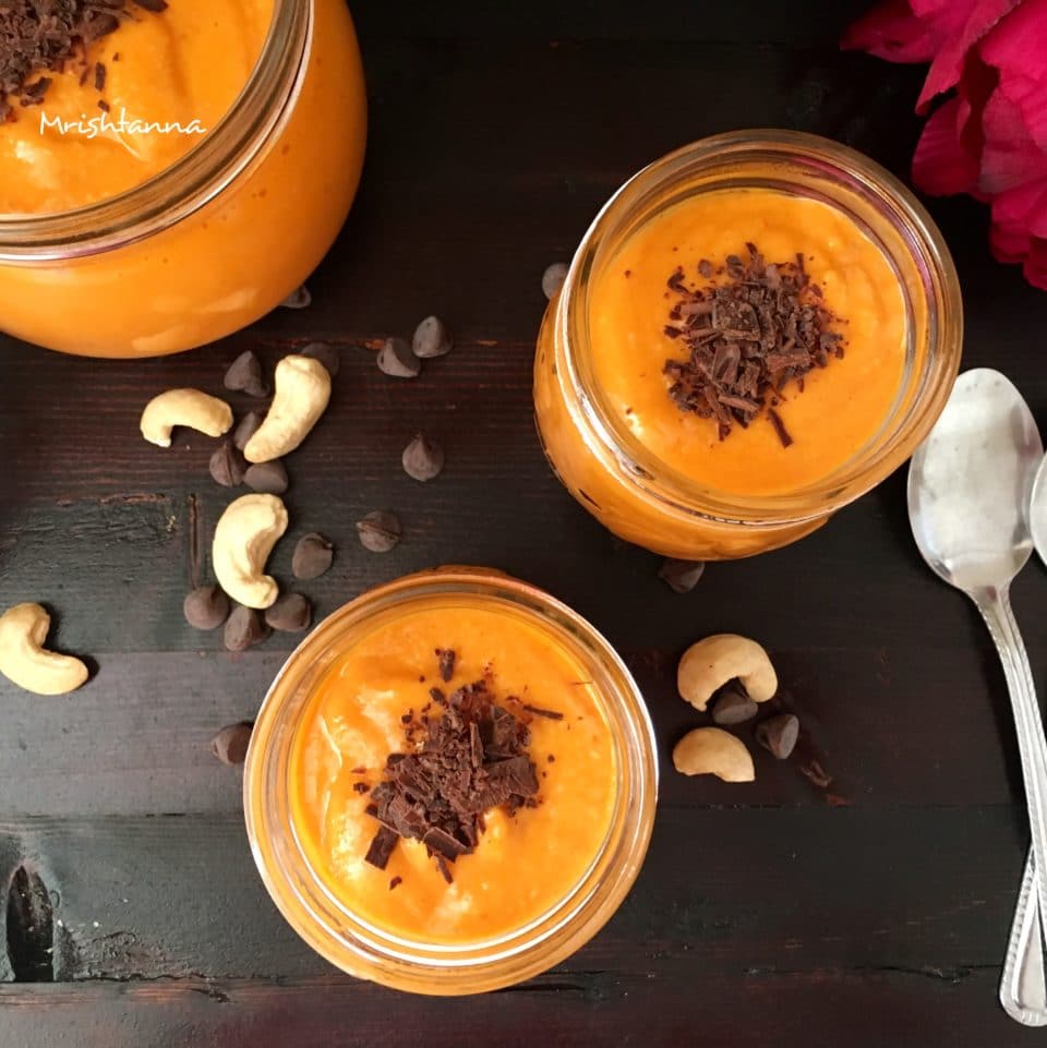 A glass of papaya mousse on a wooden table