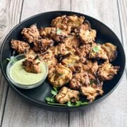 A plate is with air fried onion pakoras.