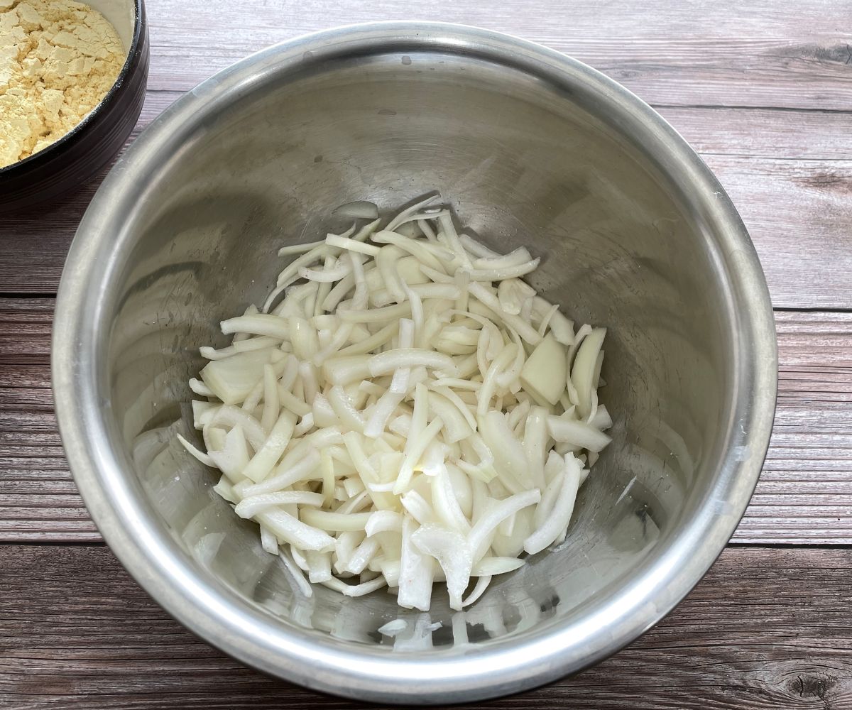 A bowl is with sliced onions and salt.