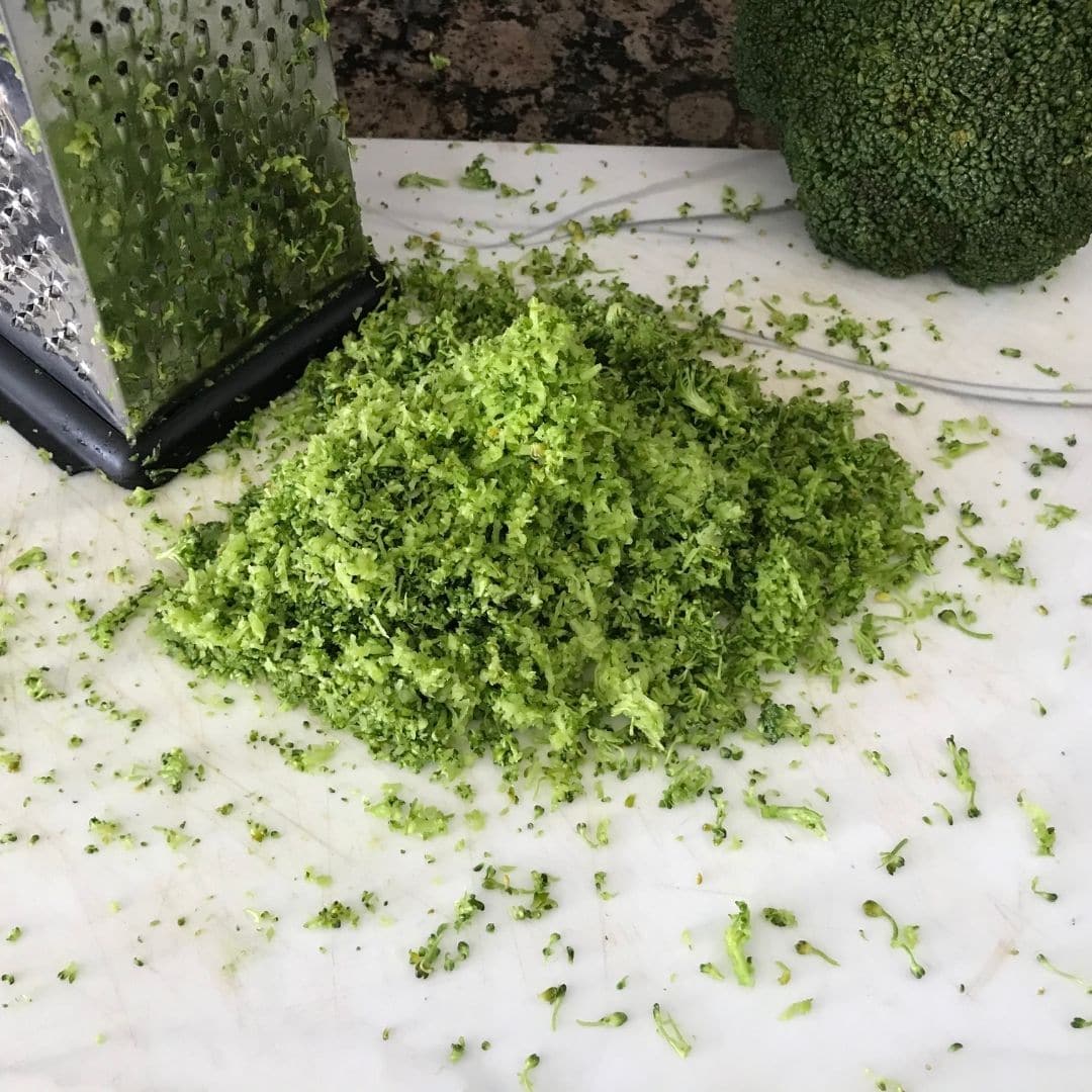 Grated broccoli is on the cutting board 