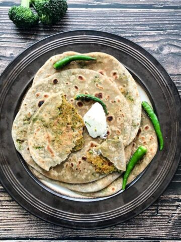 broccoli paratha's are on the big brown plate and topped with vegan butter