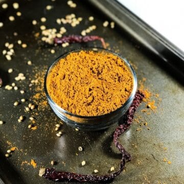 A bowl is with sambar powder and is placed on the tray