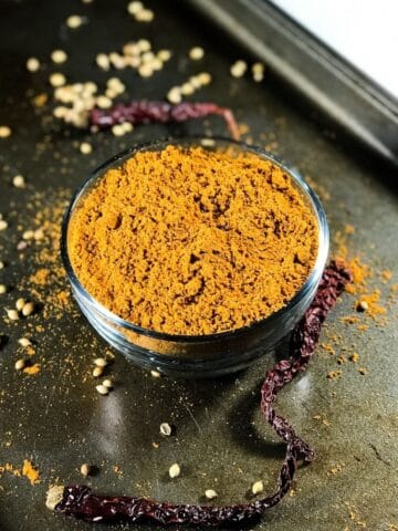 A bowl is with sambar powder and is placed on the tray