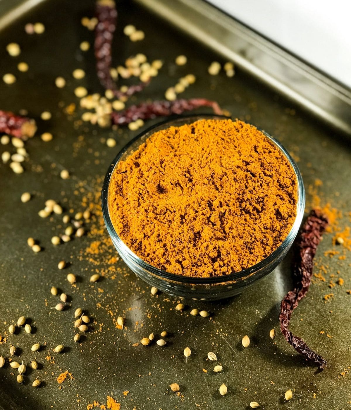 A bowl with sambar powder is on the baking tray