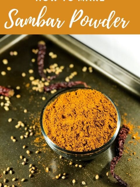 A glass bowl with sambar powder is on the tray