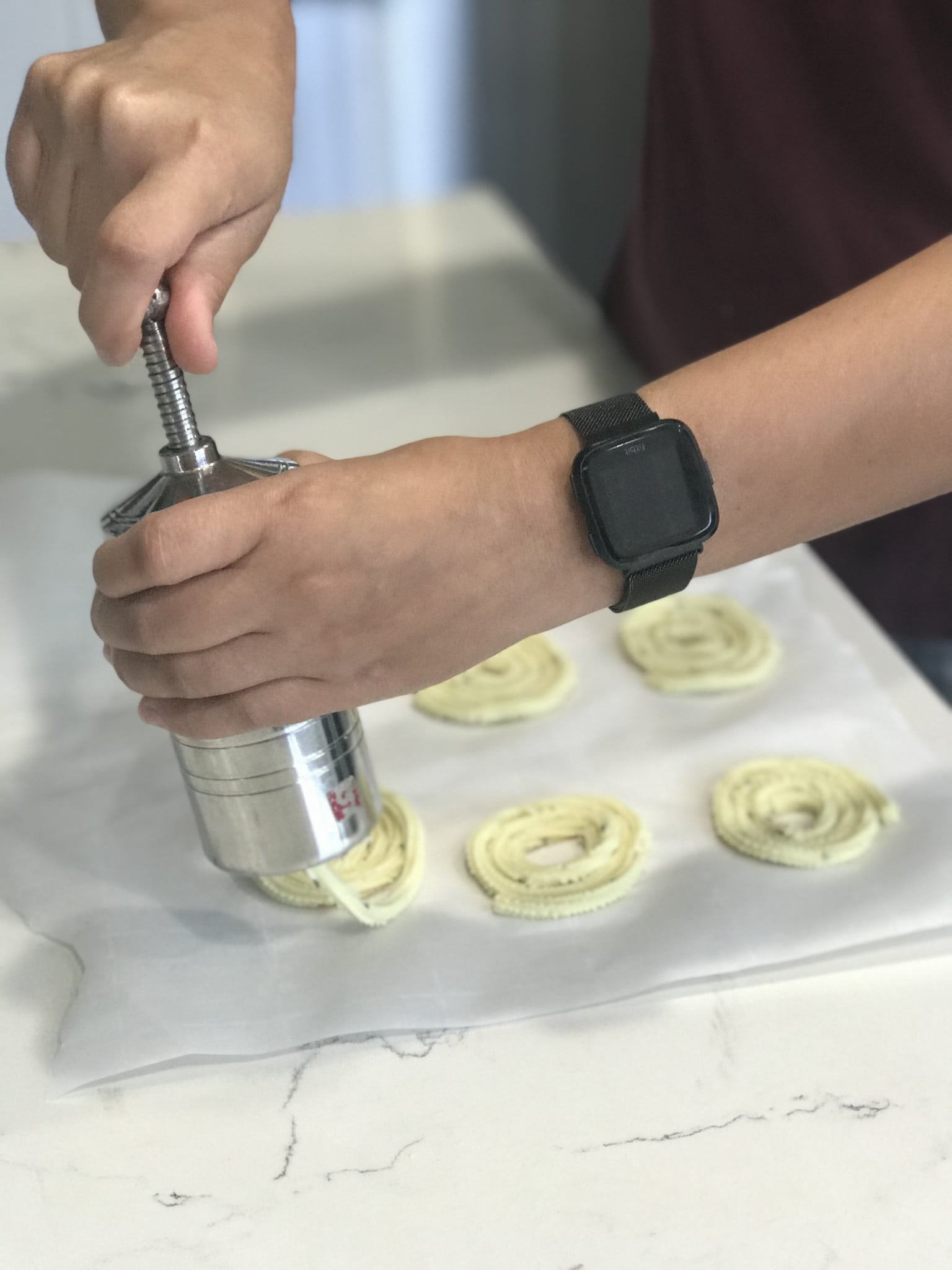 A lady is pressing the chakli dough into circular shape on the counter tops