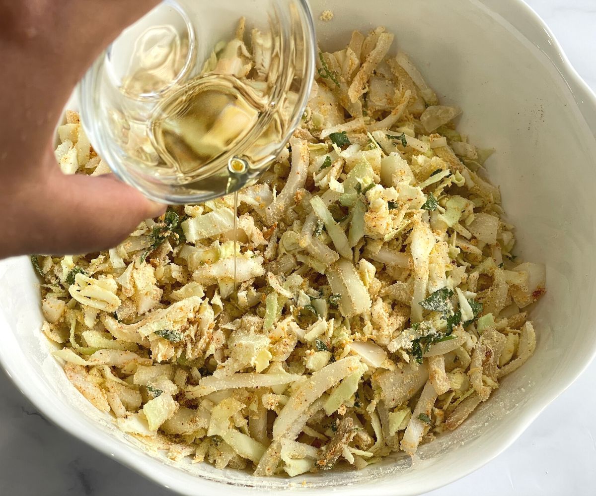 A bowl is with cabbage pakora mixture.