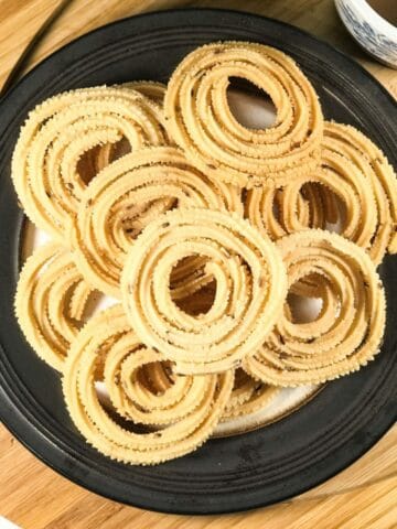 A plate is with chakli on the table