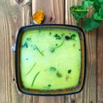 A bowl of moong dal rasam and topped with cilantro