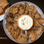 A plate of eggplant dosa with raita