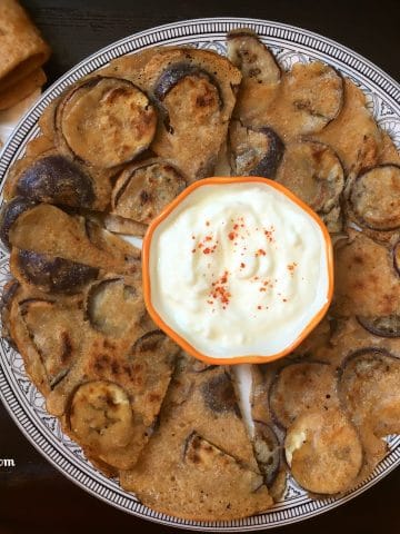 A plate of eggplant dosa with raita