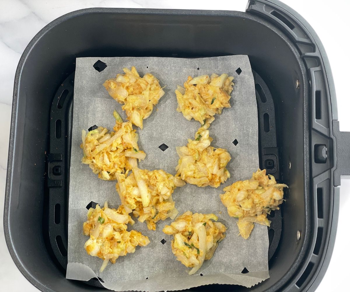 Air fryer basket is with cabbage pakora batter.