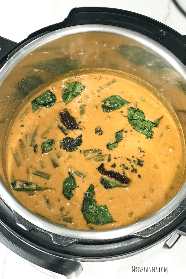 A bowl of sambar sitting on top of a stove 