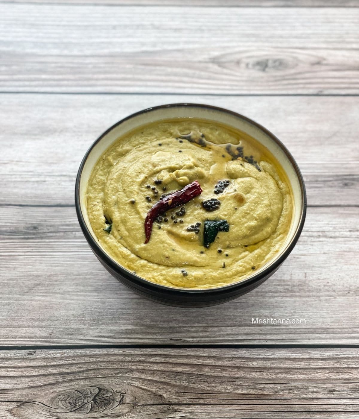 A bowl of ridge gourd chutney is on the table.