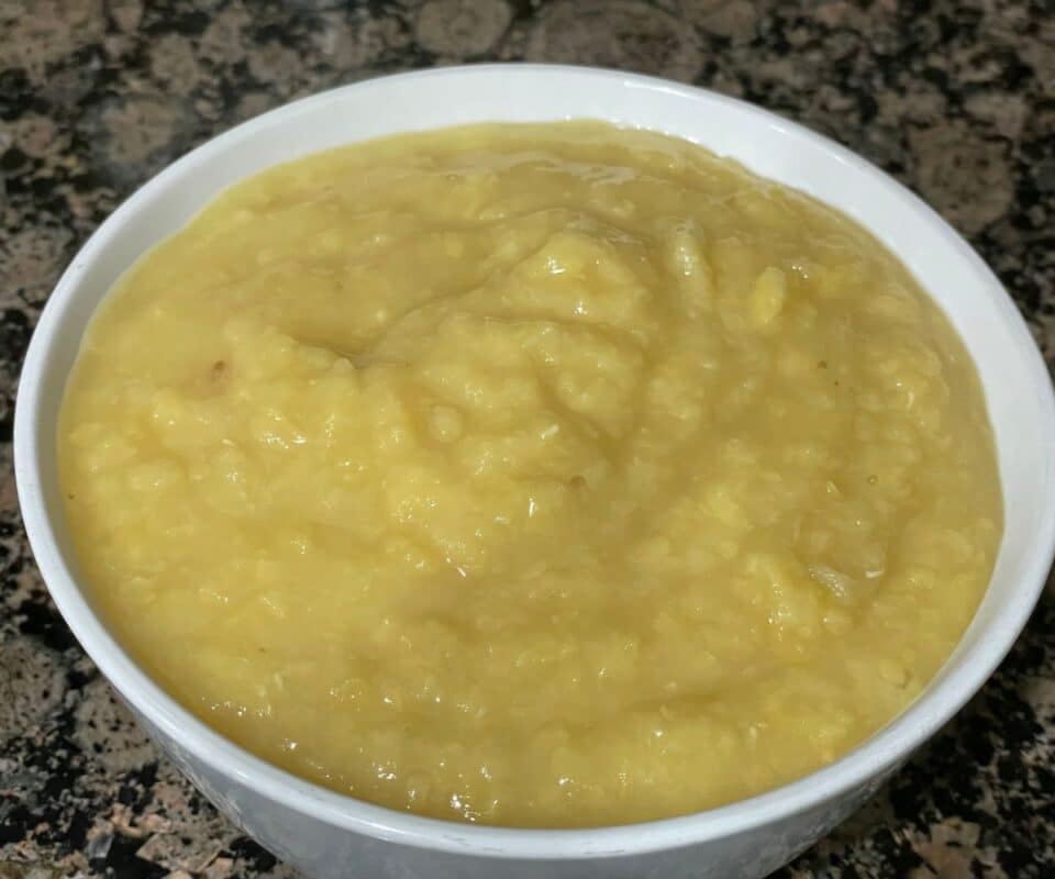 A bowl is with cooked mashed creamy lentils.