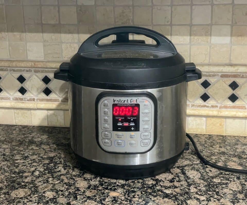 An instant pot is with mixed lentils on pressure cooking mode.