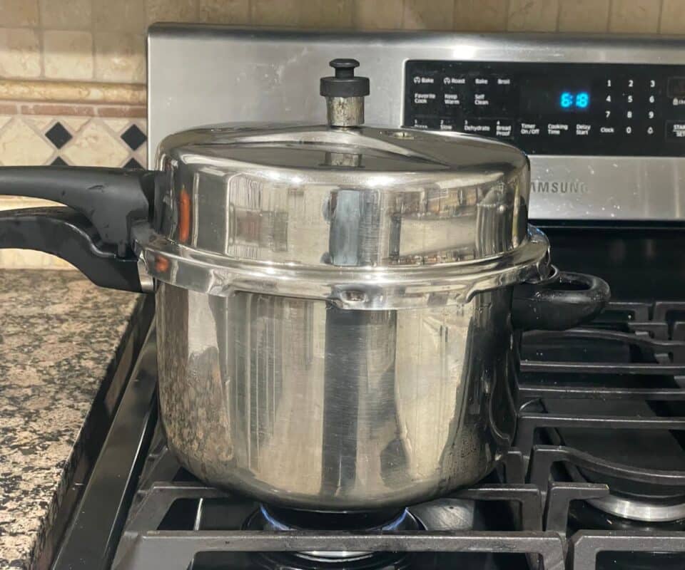 A pressure cooker filled with dal is on the stovetop.