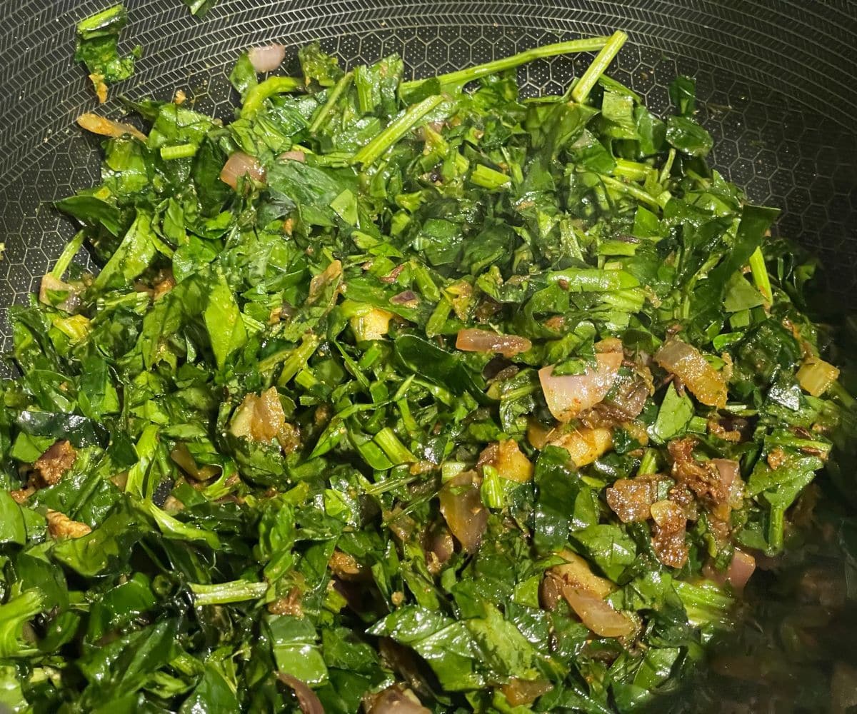 A pan is with spinach and other ingredients.