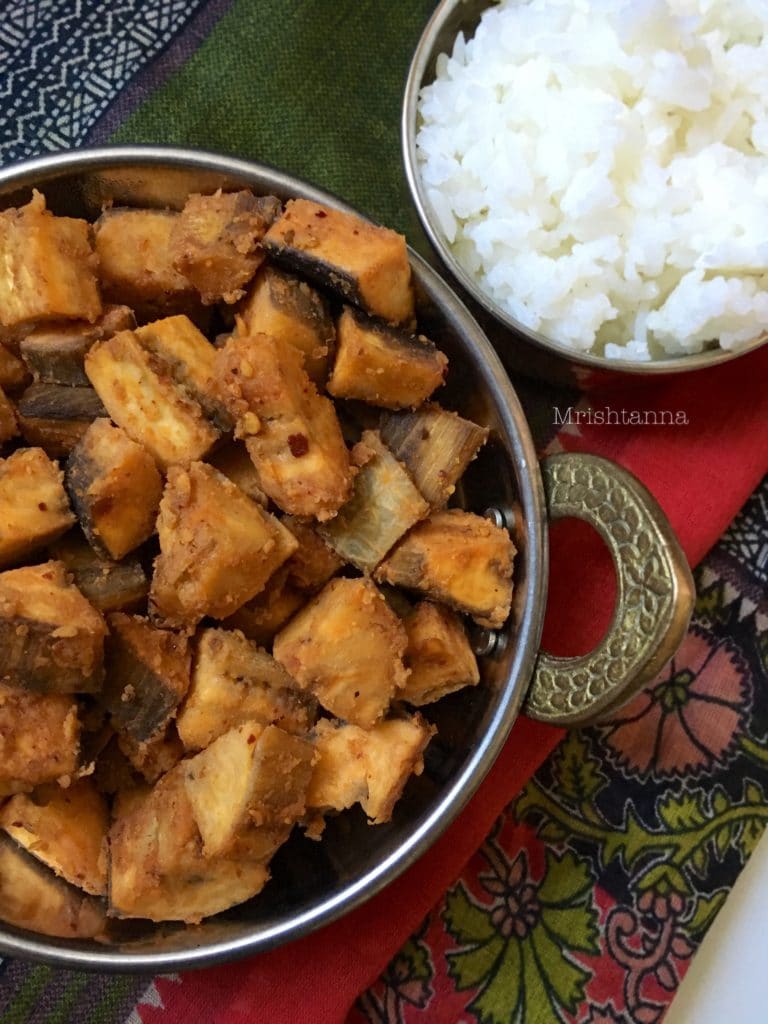 Plantain stir fry A bowl of food on a plate, with Sambar and Curry