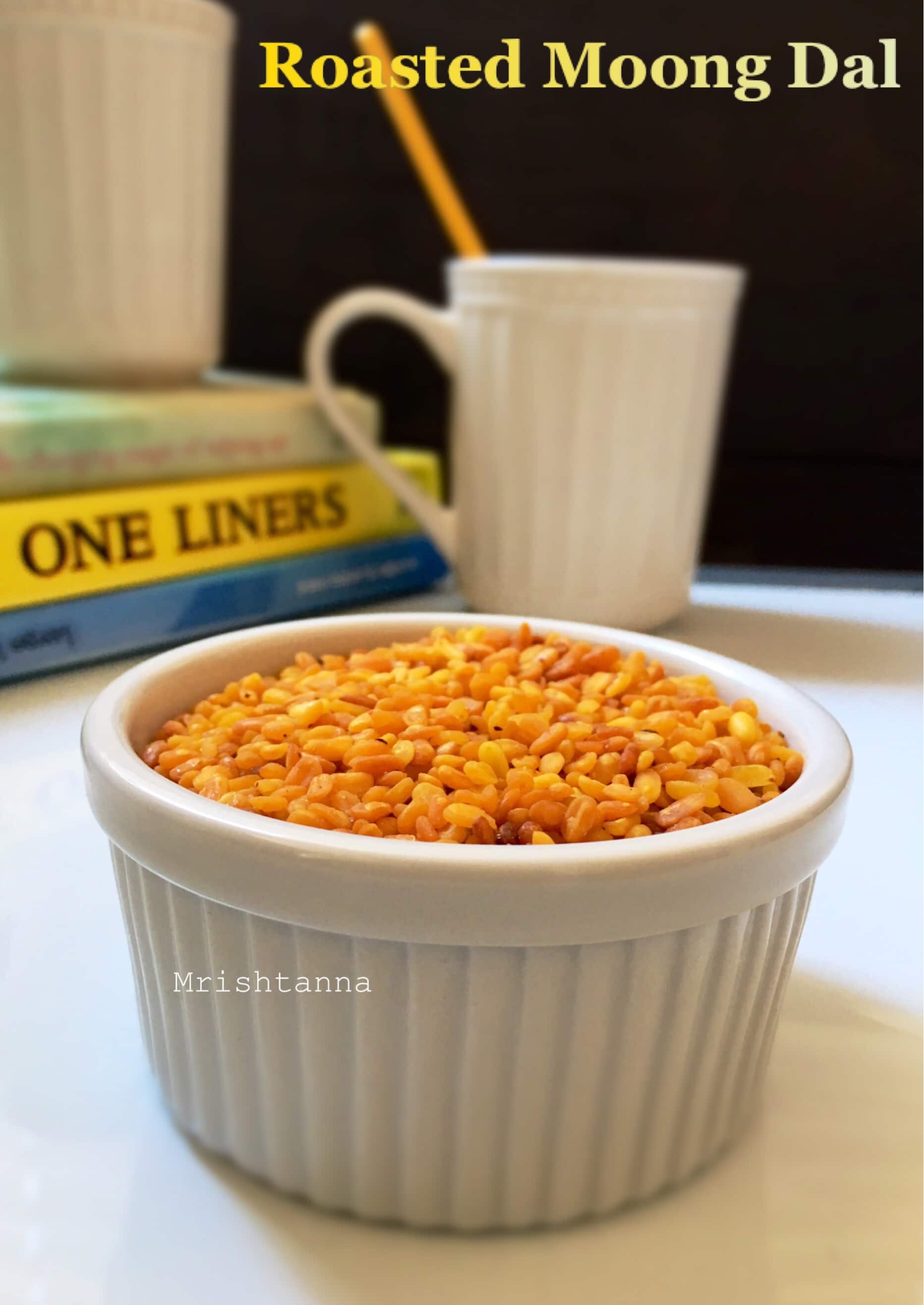 A cup of roasted yellow moong dal on the table along with cup of chai