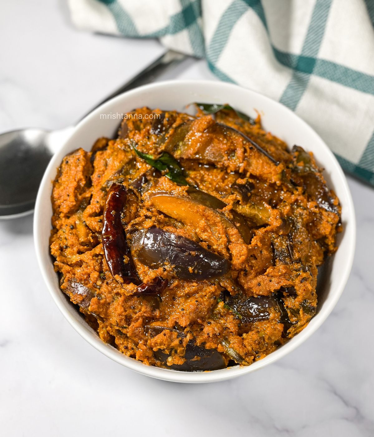 A bowl of South Indian Eggplant curry is on the table.