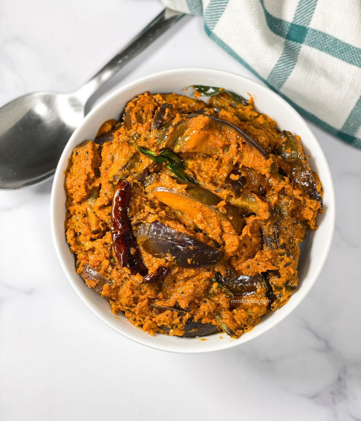 A bowl is full of south Indian brinjal curry.