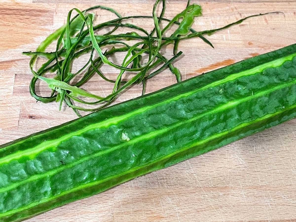 peeled ridge gourd is on the cutting board.