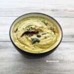 A bowl is filled with ridge gourd chutney and topped with tempering.