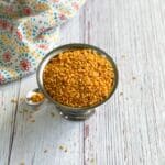 A steel bowl is with an air fryer roasted moong dal.