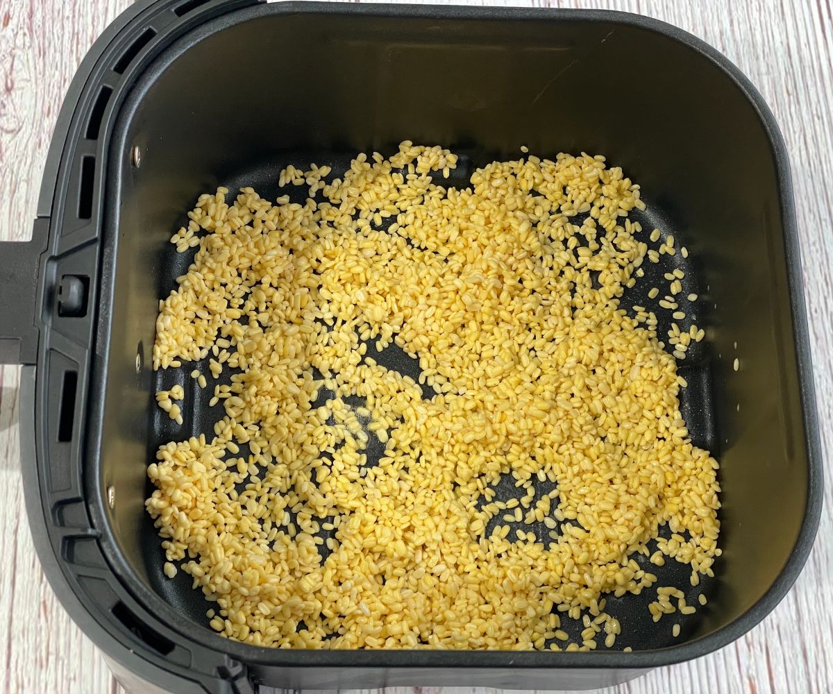 Air fryer basket is with soaked and dry moong dal.