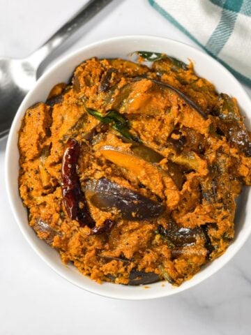 A bowl of brinjal curry is on the surface.