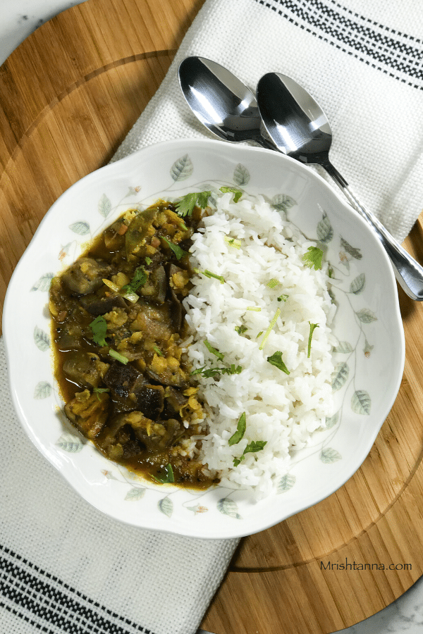 A bowl of food on a plate, with Sambar and Rice