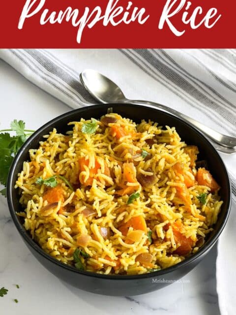 A bowl of pumpkin rice is on the table along with a spoon and a napkin.