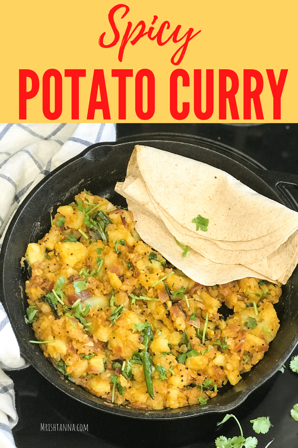 Pan is with potato curry and placed on the wooden table.