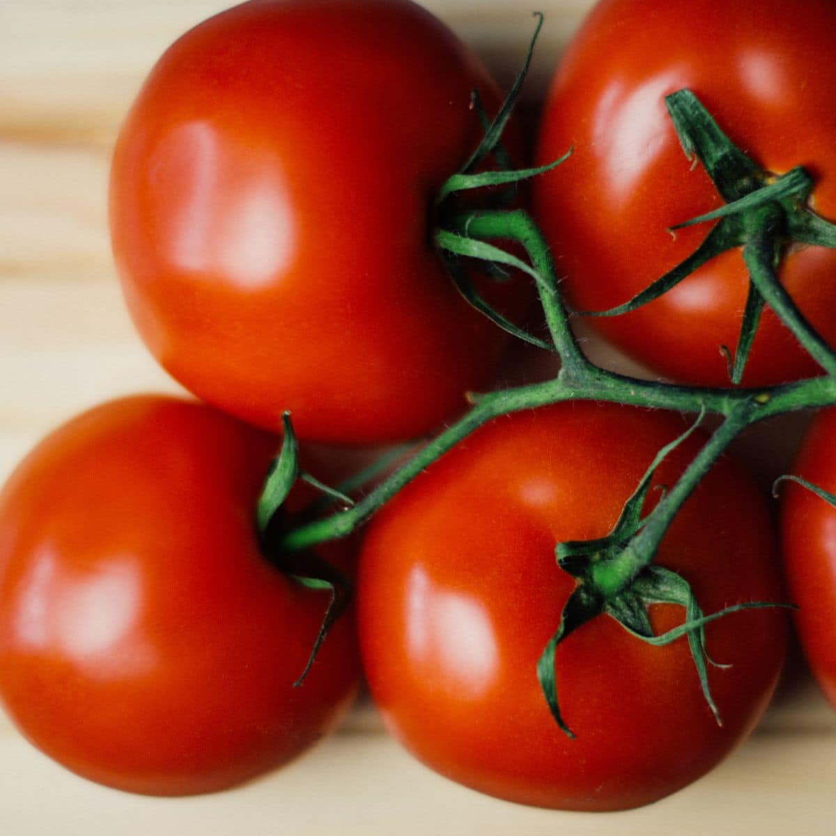 Tomatoes are placed on the wooden surface.