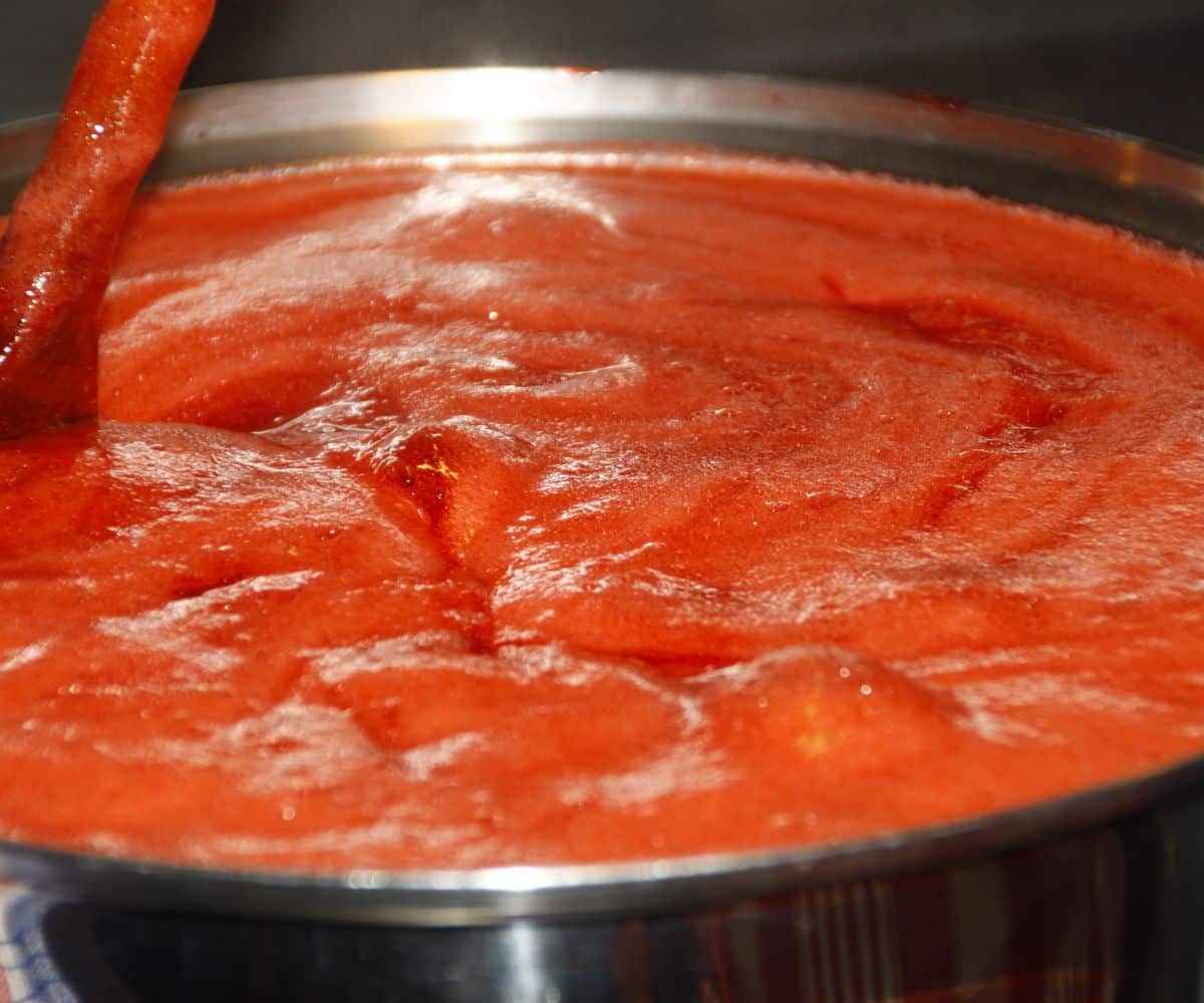 A pan is with tomato puree to make jam.