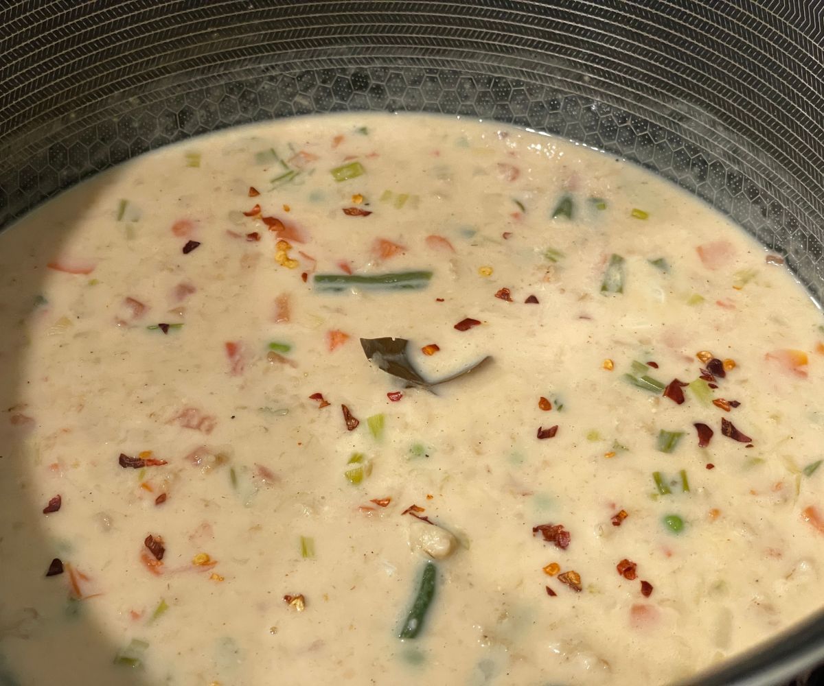 A pan is full of oatmeal soup over the heat.