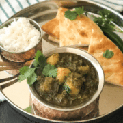 A bowl of food on a plate, with Curry