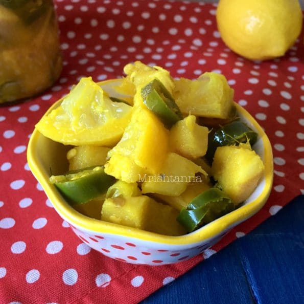 A bowl of lemon pickle sitting on a table, with Lemon and Salt