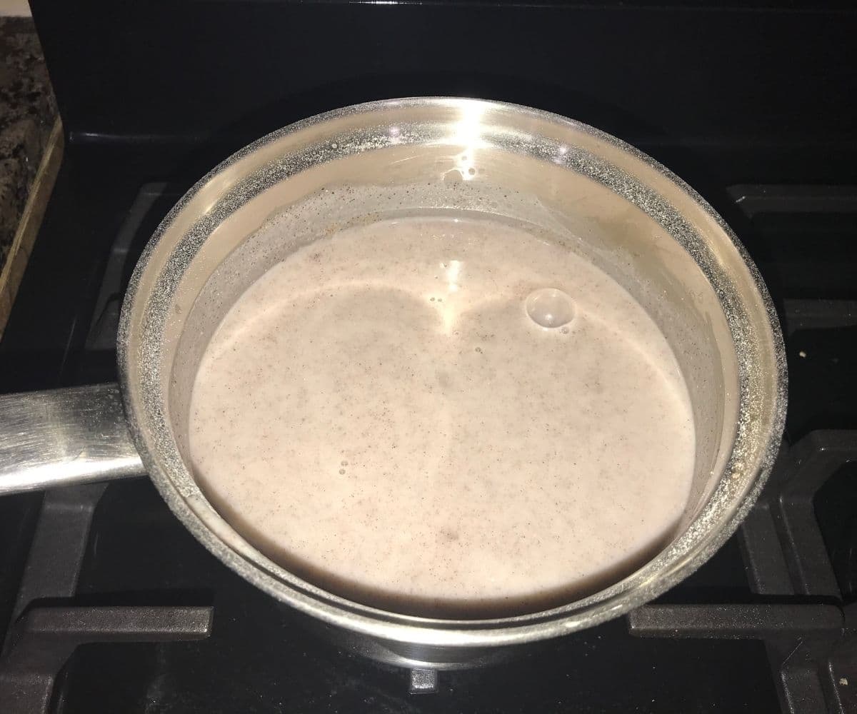 A pot is with ragi malt and cooking over the heat