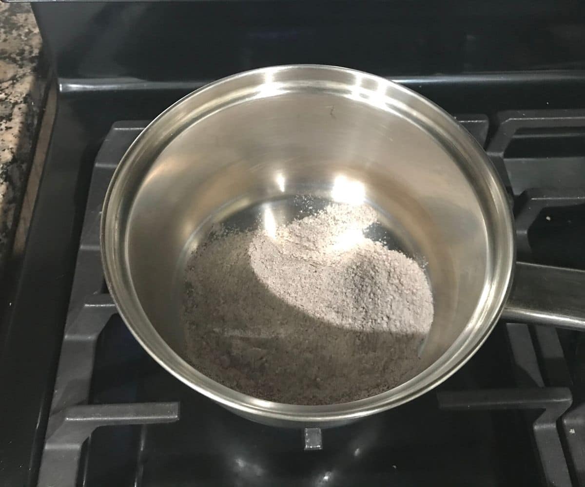 A pan is filled with finger millet flour over the heat