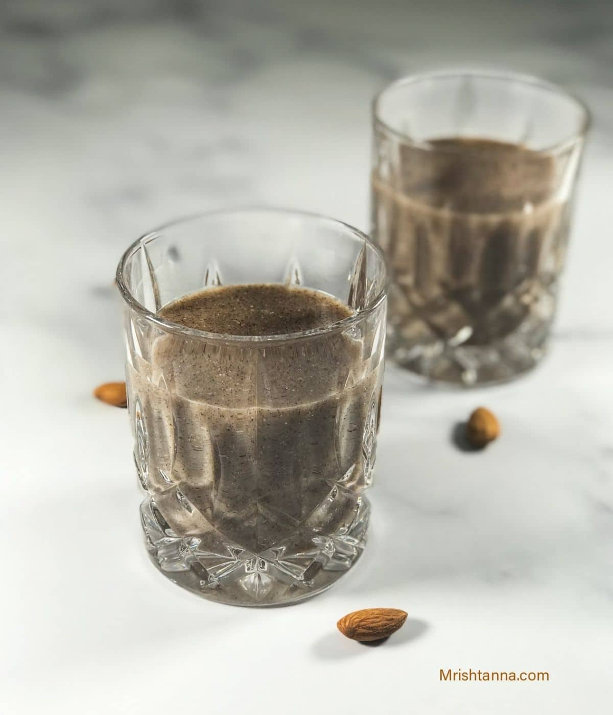 A glass is with ragi malt drink on the white board.