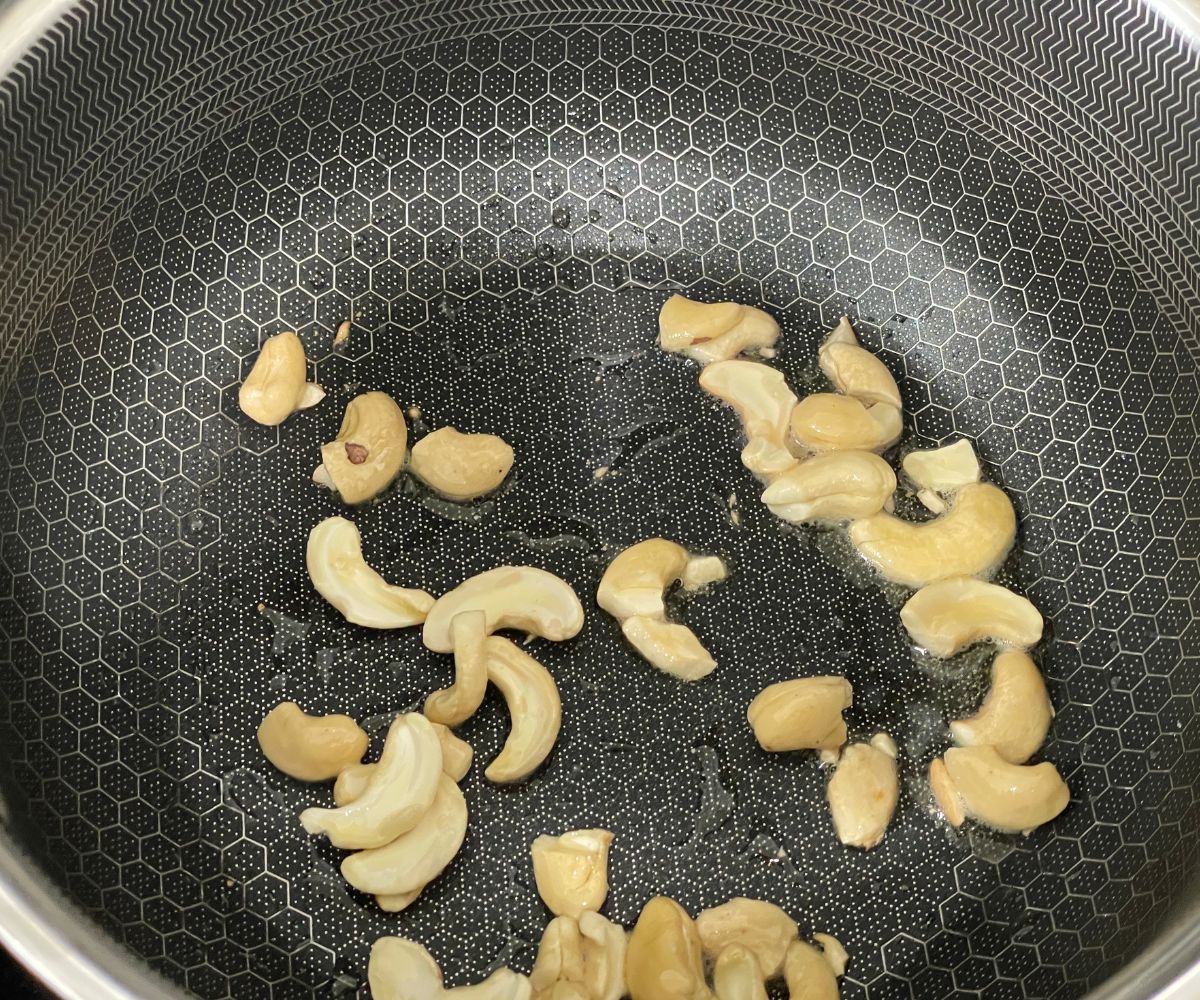 A pan is with roasted cashew nuts.