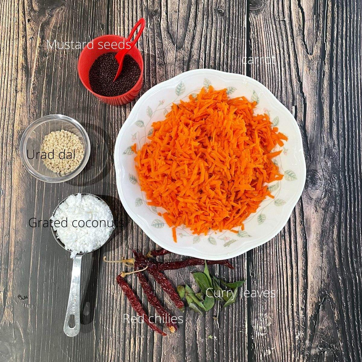 A table is with carrot chutney ingredients like grated carrots, coconuts, and spices.