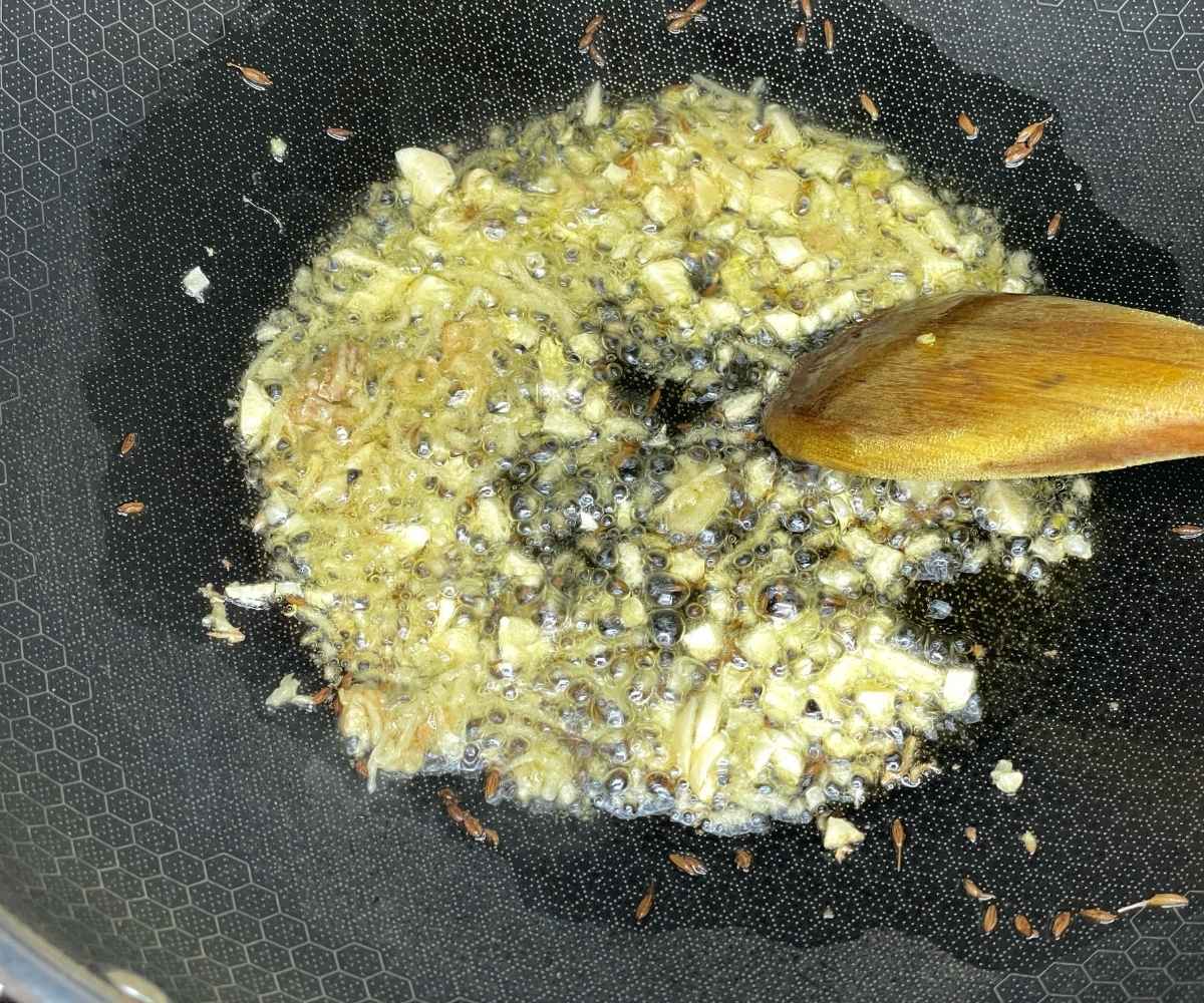 A pan is with garlic and ginger over the heat.