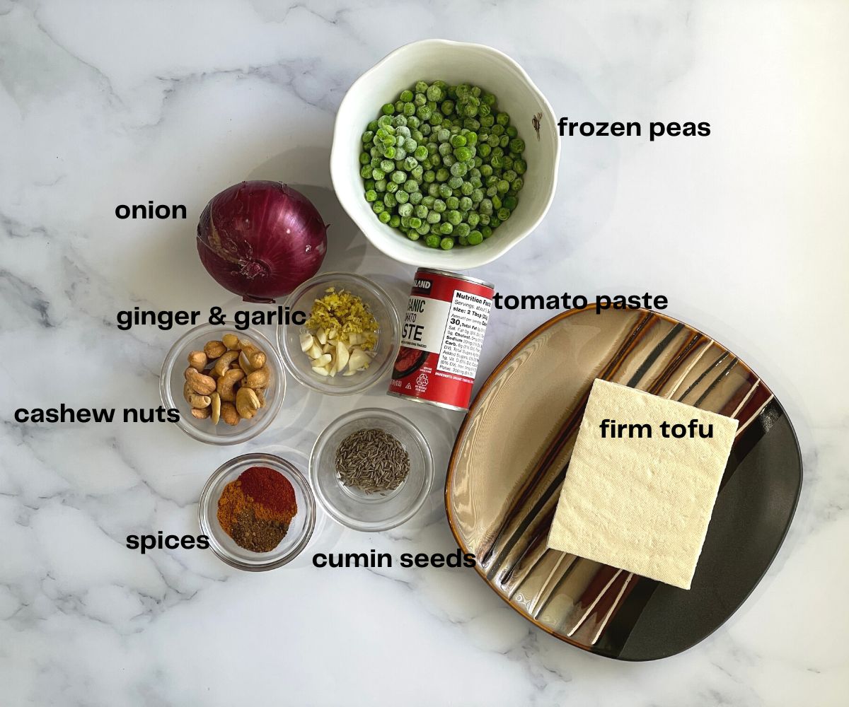 a table is filled with tofu matar recipe ingredients.