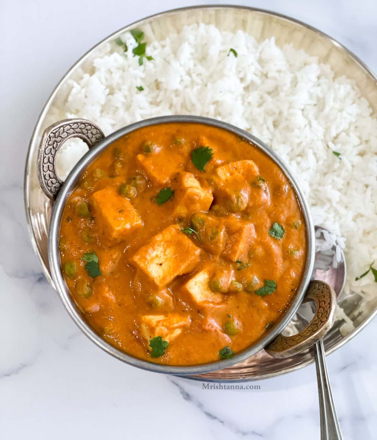 Head shot of a bowl with vegan matar paneer and rice.