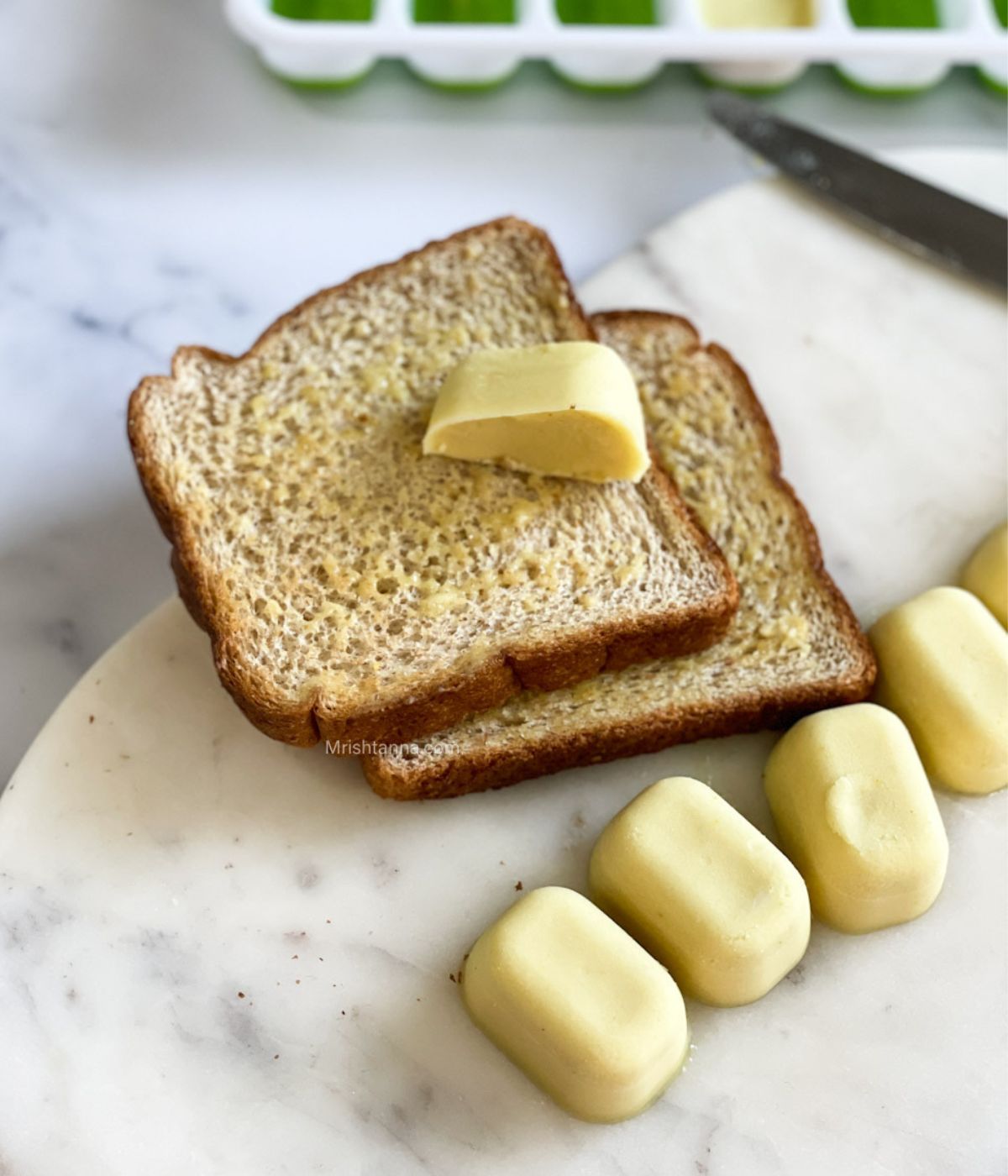 A toasted bread is with vegan butter cubes.